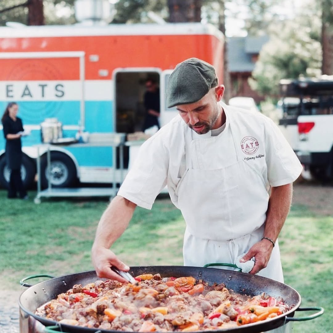 Chef Tommy cooking paella beside the EATS food truck
